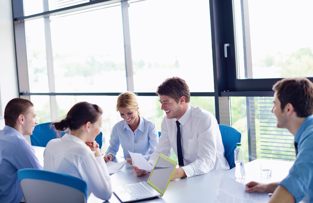 Group of happy young business people in a meeting at office