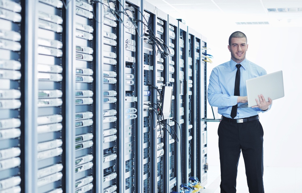 young engeneer business man with thin modern aluminium laptop in network server room